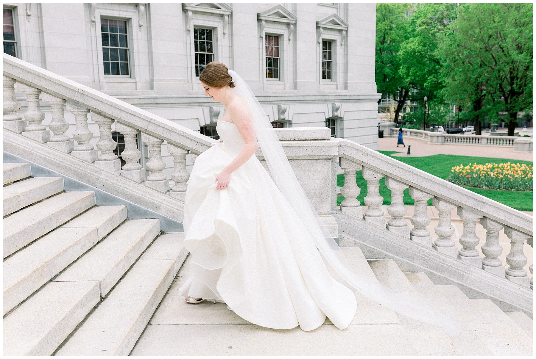 bride in white gown walking up steps