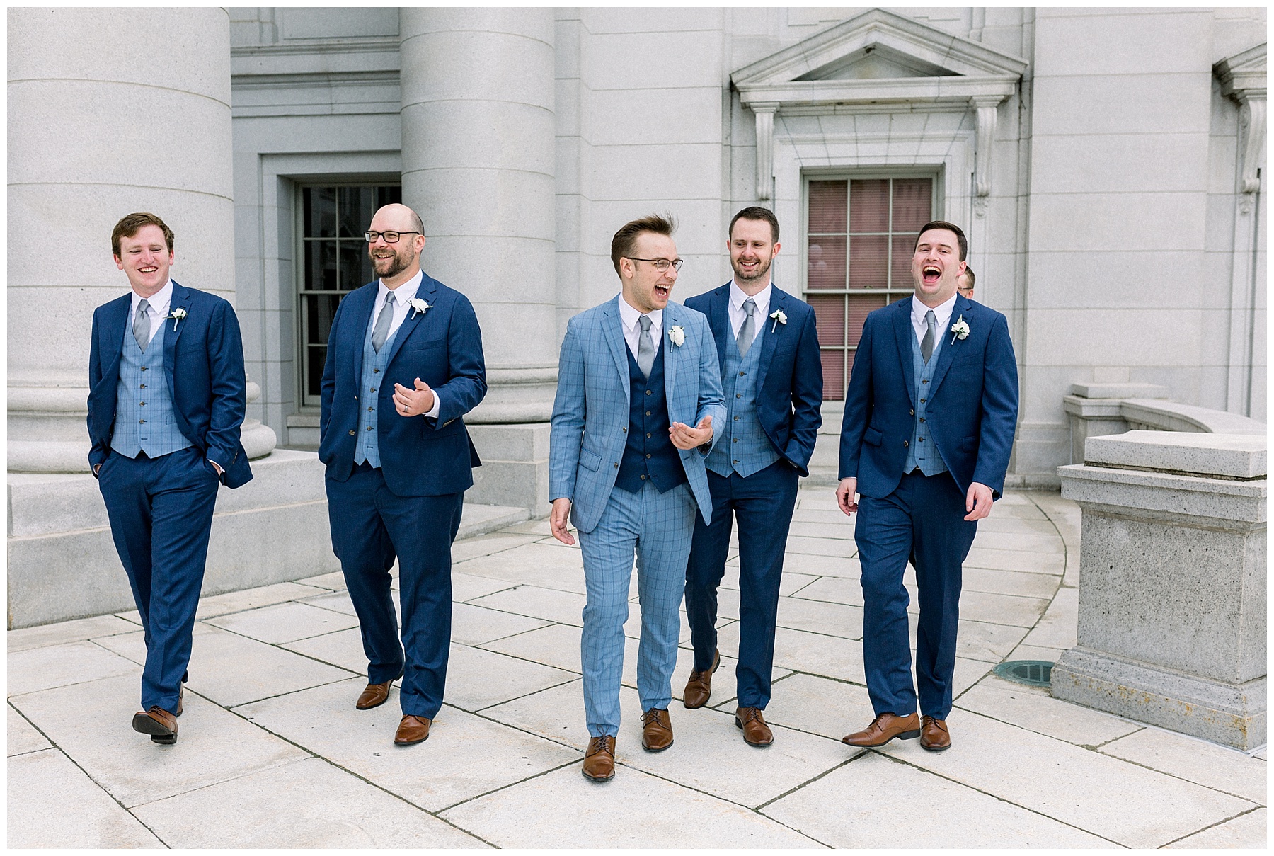groomsmen laughing in blue suits